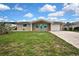 Charming single-story home featuring a brick facade, turquoise shutters, and a well-maintained front yard at 12637 2Nd Isle, Hudson, FL 34667