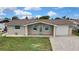 Single-story home with brick exterior, turquoise shutters, paved driveway, and well-kept lawn at 12637 2Nd Isle, Hudson, FL 34667