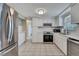 Bright kitchen with stainless steel appliances, white cabinets and subway tile backsplash at 12637 2Nd Isle, Hudson, FL 34667