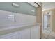 Kitchen with white cabinets, light countertops, and access to additional rooms at 12637 2Nd Isle, Hudson, FL 34667