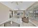 Bright sunroom with tile floors, multiple windows, ceiling fans, and comfortable wicker furniture at 12637 2Nd Isle, Hudson, FL 34667