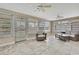 Bright sunroom with tile floors, multiple windows, ceiling fans, and comfortable wicker furniture at 12637 2Nd Isle, Hudson, FL 34667