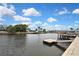 Waterfront view featuring a private dock, boat lift, and beautiful blue sky with clouds at 12637 2Nd Isle, Hudson, FL 34667