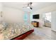 Bright bedroom boasts a ceiling fan, natural light, and a view into an adjacent living room at 13349 Niti Dr, Hudson, FL 34669