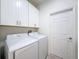 Laundry room area featuring a white washer and dryer with white cabinets at 13349 Niti Dr, Hudson, FL 34669