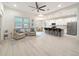 Open-concept living space with hard wood floors and a view of the kitchen and dining area at 13349 Niti Dr, Hudson, FL 34669
