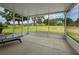 Screened in patio with black lounge chair and views of the landscaped backyard at 13349 Niti Dr, Hudson, FL 34669