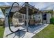 Charming outdoor patio with hanging chair, stylish seating area, and covered pergola at 14011 Shoal Dr, Hudson, FL 34667