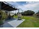 Relaxing outdoor patio featuring a hanging egg chair, shaded seating area, and lush green surroundings at 14011 Shoal Dr, Hudson, FL 34667