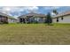 A spacious backyard with a healthy lawn, complemented by a home featuring a screened-in porch and ample natural light at 14011 Shoal Dr, Hudson, FL 34667