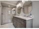 A renovated bathroom boasts a double sink vanity with marble countertop and a glass-enclosed shower at 14011 Shoal Dr, Hudson, FL 34667
