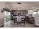 Dining room with elegant lighting and an adjacent kitchen and sliding door access to the backyard at 14011 Shoal Dr, Hudson, FL 34667