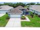 Beautiful single-story home with a well-manicured front yard, driveway, and blue exterior at 14011 Shoal Dr, Hudson, FL 34667