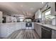 A modern kitchen featuring white cabinetry, stainless steel appliances, and an open layout to the living room at 14011 Shoal Dr, Hudson, FL 34667