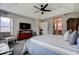 Bright main bedroom showcasing a ceiling fan, TV, and a glimpse into the ensuite bathroom at 14011 Shoal Dr, Hudson, FL 34667