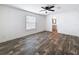 This bedroom has wood-look flooring, neutral paint, ceiling fan, and ensuite bathroom at 16037 Brookridge Blvd, Brooksville, FL 34613