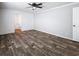 Bedroom featuring wood-look flooring, neutral paint, ceiling fan, and ensuite bathroom at 16037 Brookridge Blvd, Brooksville, FL 34613