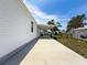 Exterior view showing the side of a well-maintained white home with a covered patio at 16037 Brookridge Blvd, Brooksville, FL 34613