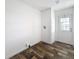 Hallway featuring wood-look flooring, white walls, and a door with decorative glass panes at 16037 Brookridge Blvd, Brooksville, FL 34613