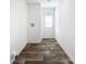 Hallway featuring wood-look flooring, white walls, and a door with decorative glass panes at 16037 Brookridge Blvd, Brooksville, FL 34613