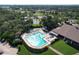 An aerial shot highlights a large community pool, tennis courts, and surrounding lush landscaping at 2139 Sea Pines Ct, Spring Hill, FL 34606