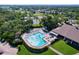 Aerial view of a community pool, clubhouse, tennis courts, and lush landscaping at 2139 Sea Pines Ct, Spring Hill, FL 34606