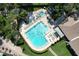 Aerial view features a large community pool with seating, a jacuzzi and manicured green spaces at 2139 Sea Pines Ct, Spring Hill, FL 34606