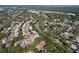 An aerial view showcases a neighborhood surrounded by mature trees and winding streets at 2139 Sea Pines Ct, Spring Hill, FL 34606