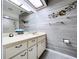 This bathroom features wood-look walls, a white vanity with a clock, and a decorative metal flower at 2139 Sea Pines Ct, Spring Hill, FL 34606
