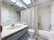 This bathroom showcases a vanity with a white countertop, a toilet, and a tub with shower curtain at 2139 Sea Pines Ct, Spring Hill, FL 34606