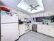 Well-lit kitchen with white cabinets, white appliances, and light-colored floors at 2139 Sea Pines Ct, Spring Hill, FL 34606