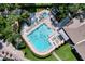 Aerial view of a large community pool with lounge chairs and umbrellas at 2139 Sea Pines Ct, Spring Hill, FL 34606
