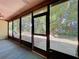 This sunroom showcases large windows, lush greenery outdoors, and a stone patio at 2139 Sea Pines Ct, Spring Hill, FL 34606