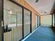 This sunroom features wood paneling, large sliding glass doors, and blue carpeting at 2139 Sea Pines Ct, Spring Hill, FL 34606