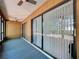 This sunroom features sliding glass doors with vertical blinds, wood paneling, and blue carpeting at 2139 Sea Pines Ct, Spring Hill, FL 34606