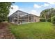 Spacious backyard showcasing the home's screened-in pool and patio at 2526 Brinley Dr, Trinity, FL 34655
