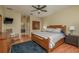 Comfortable bedroom features a wooden bed frame, ceiling fan, and ensuite bathroom at 2526 Brinley Dr, Trinity, FL 34655