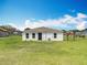 Home's backyard with healthy green grass, simple siding, and a fenced perimeter at 277 Hampshire Ave, Spring Hill, FL 34606