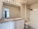 Bathroom featuring a double sink, a shower-tub combo, grey wood floors, and an entry to a bedroom at 277 Hampshire Ave, Spring Hill, FL 34606