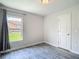 Bright bedroom featuring a neutral color palette, a window and wood-look gray flooring at 277 Hampshire Ave, Spring Hill, FL 34606