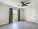 Bright bedroom featuring wood plank flooring, a window with dark curtains and neutral paint at 277 Hampshire Ave, Spring Hill, FL 34606