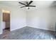 Bedroom with grey wood floors, a ceiling fan, and an ensuite bathroom entrance to the left at 277 Hampshire Ave, Spring Hill, FL 34606
