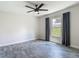 A bedroom with grey wood floors, a ceiling fan, and a window with exterior views at 277 Hampshire Ave, Spring Hill, FL 34606