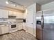 Well-lit kitchen features white cabinetry and stainless steel refrigerator at 277 Hampshire Ave, Spring Hill, FL 34606