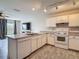 Open kitchen with white cabinets, granite counters, and view to living area at 277 Hampshire Ave, Spring Hill, FL 34606