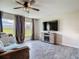 Open living room featuring an entertainment center with an electric fireplace, ceiling fan and grey plank flooring at 277 Hampshire Ave, Spring Hill, FL 34606