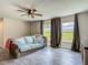 Living room featuring wood-look tile flooring, ceiling fan, and backyard view at 277 Hampshire Ave, Spring Hill, FL 34606