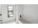 Bathroom with window with a tiled shower-tub combo and a stylish black showerhead at 3427 Charmwood Ave, Spring Hill, FL 34609
