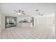 Spacious living area with white tile floors leads to an enclosed patio and modern kitchen at 3427 Charmwood Ave, Spring Hill, FL 34609