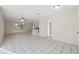 Open-concept living room with sleek tile flooring, recessed lighting, and access to the kitchen at 3427 Charmwood Ave, Spring Hill, FL 34609